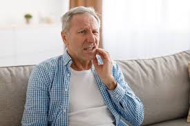 old person holding his cheek