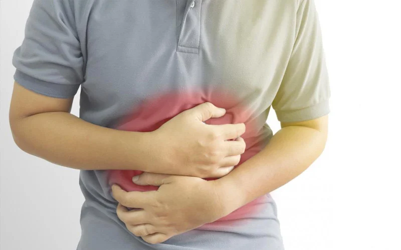 Person suffering with heartburn holding his belly