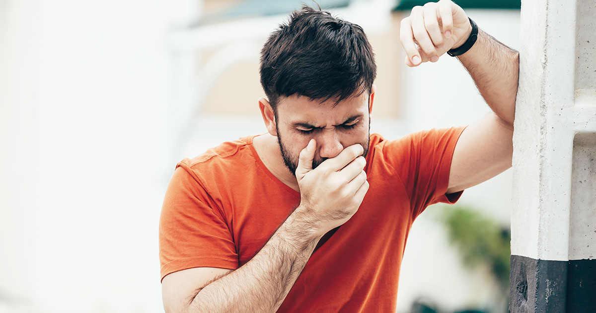 person with nausea hand covering mouth