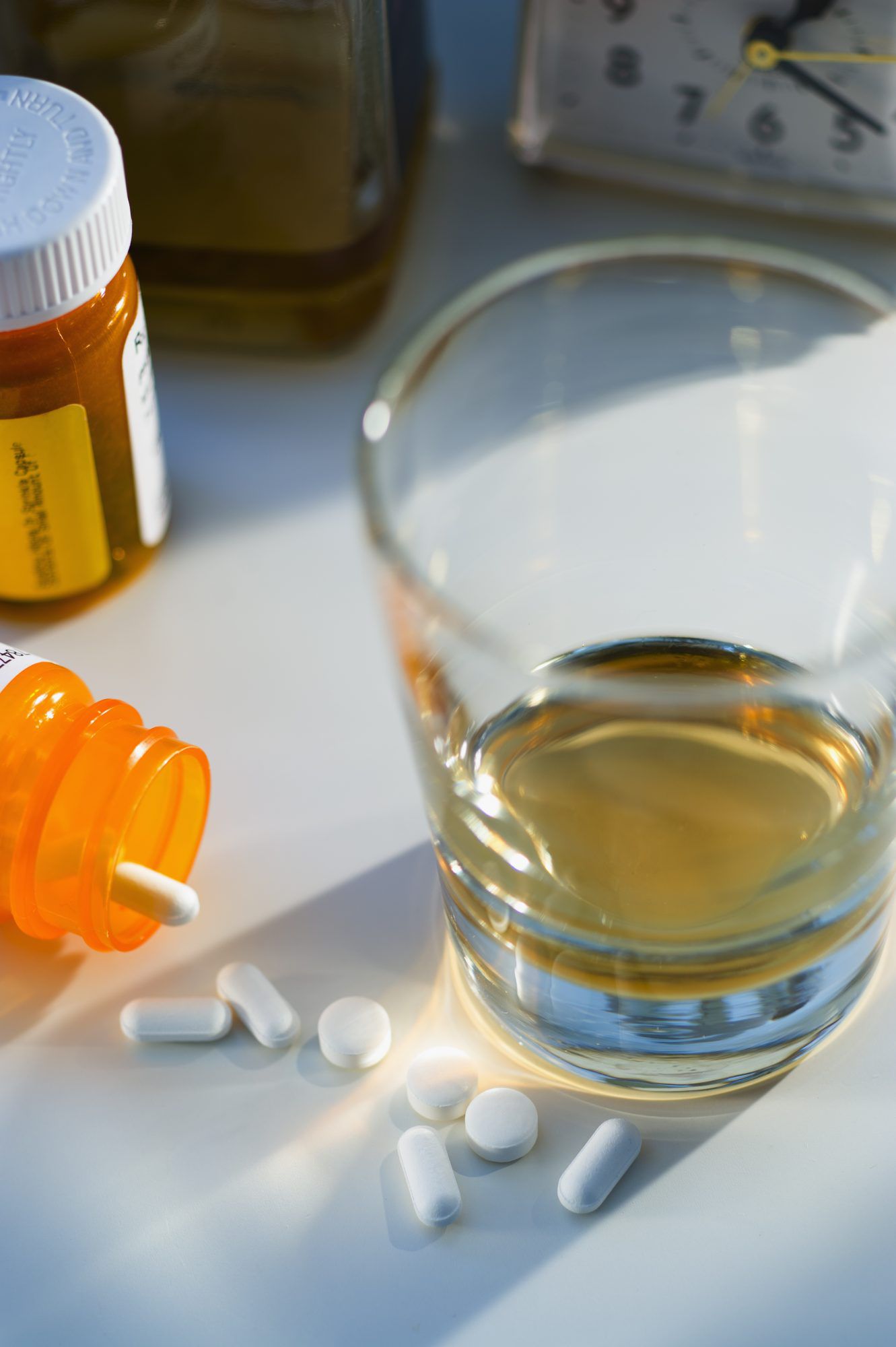 glass with alcohol alongside medicine
