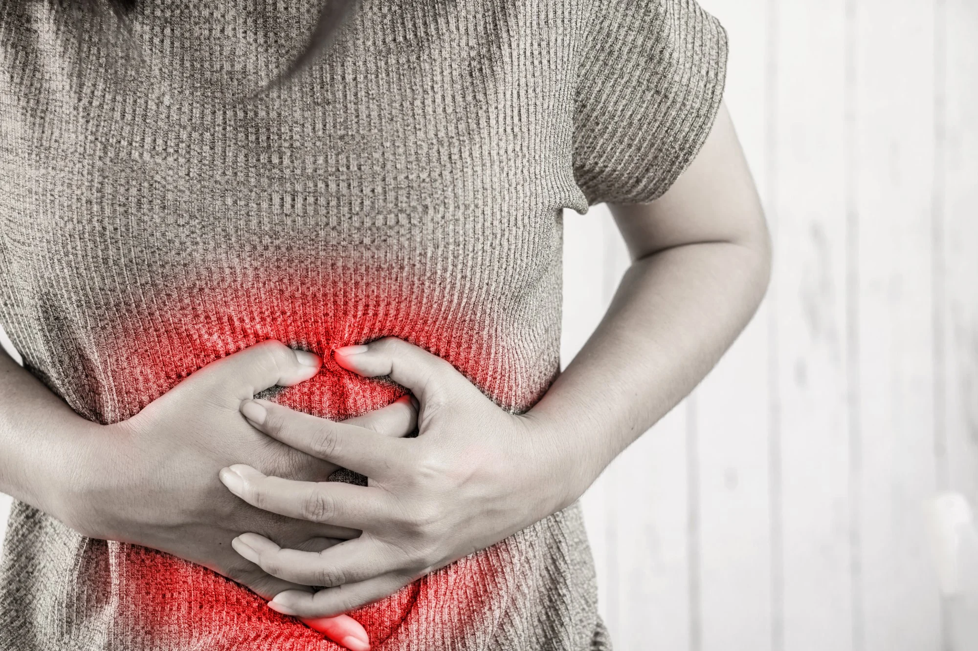 person with stomach ache holding stomach