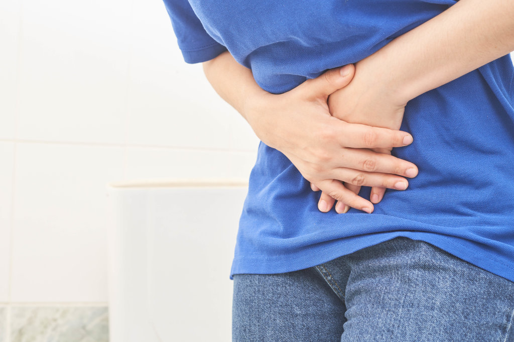 blue shirt woman having stomach ache