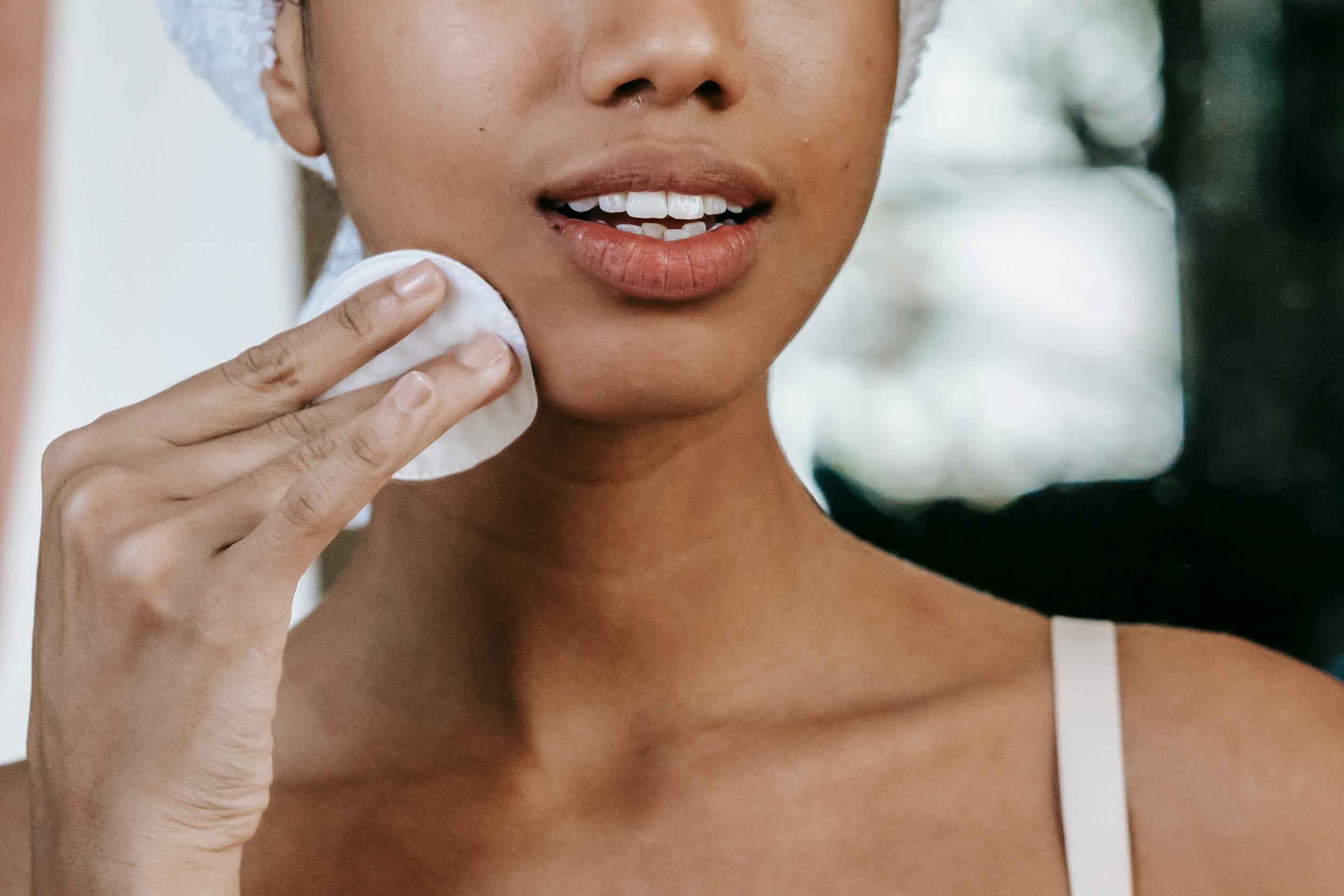woman applying solution with cotton pad