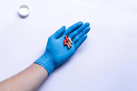 gloved hands holding medicine