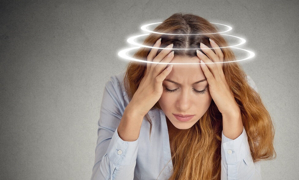woman holding head feeling dizzy