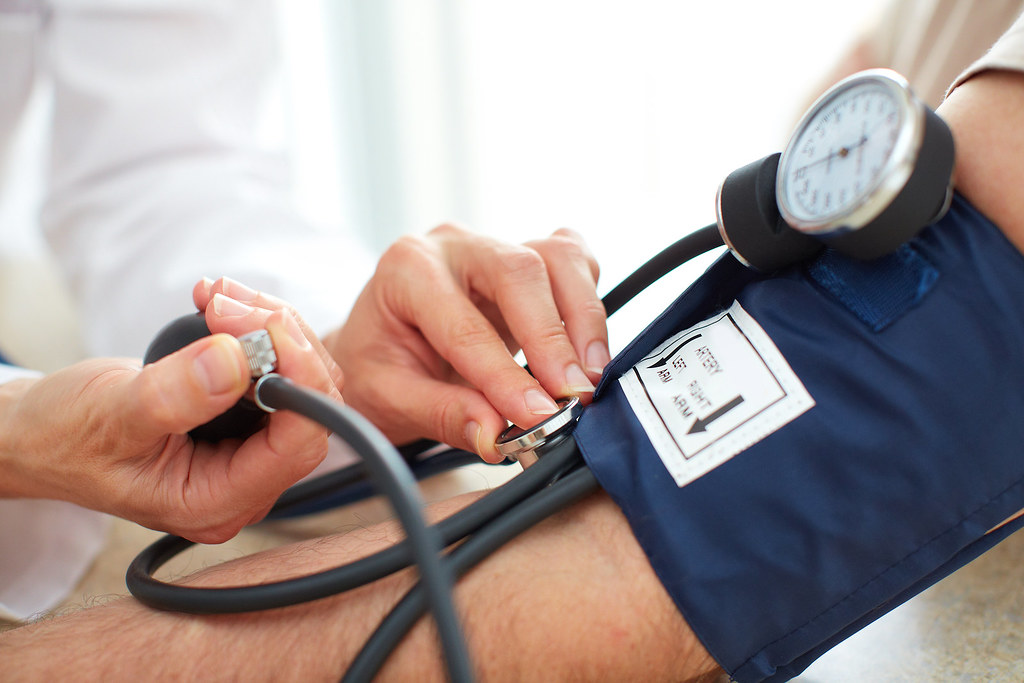 doctor checking patient blood pressure 