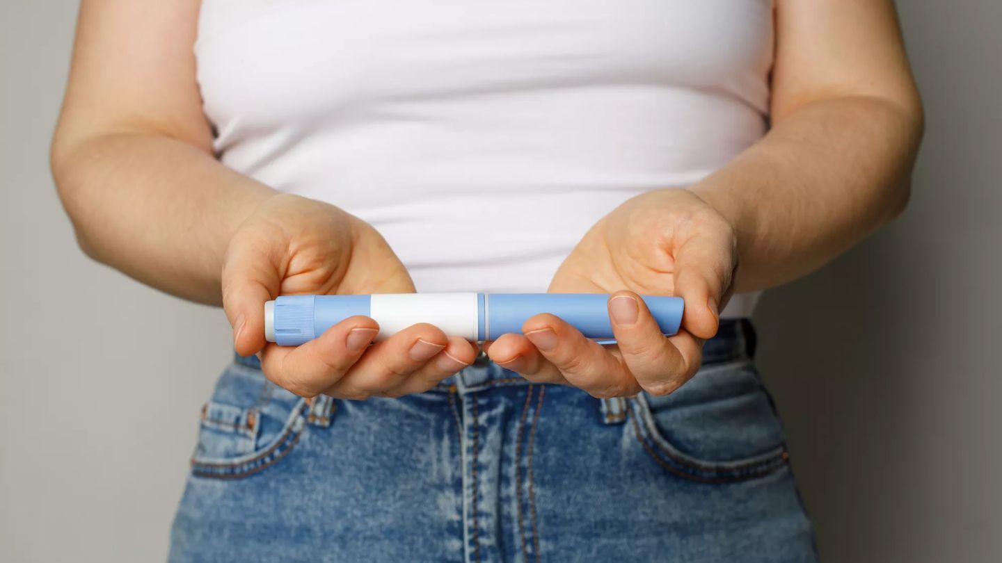 lady standing with pen filled injection infront of stomach