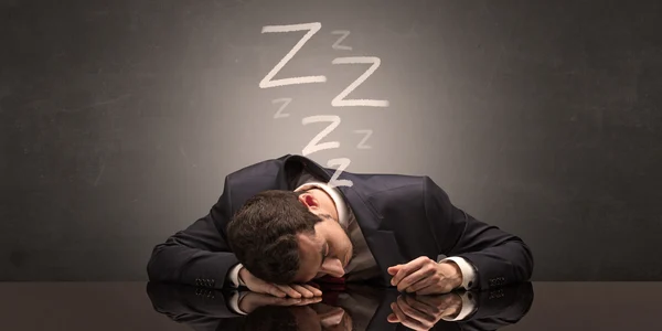person sleeping on desk black suit drowsy
