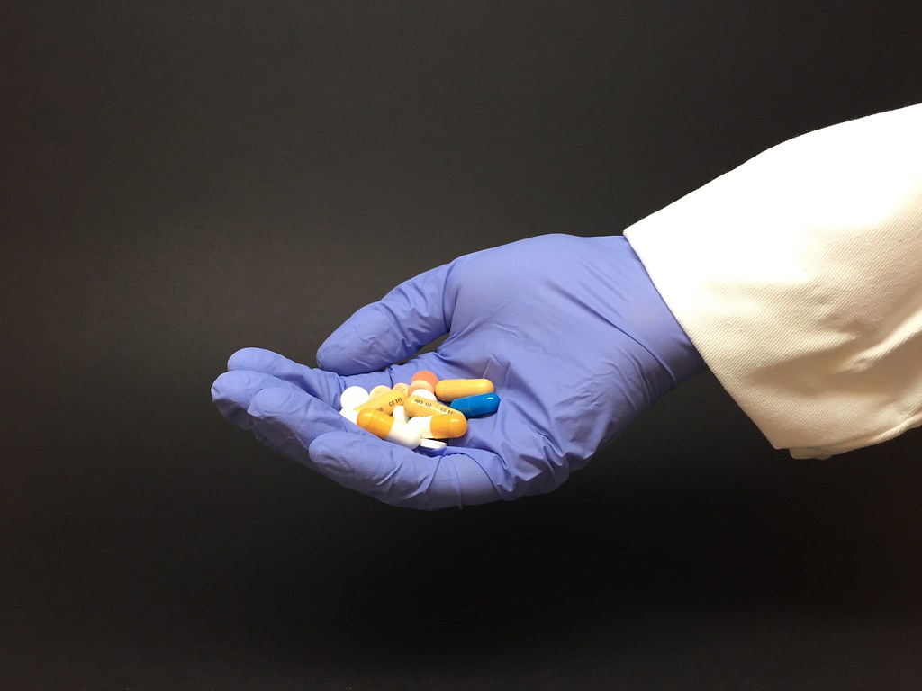 gloved hand holding medicine