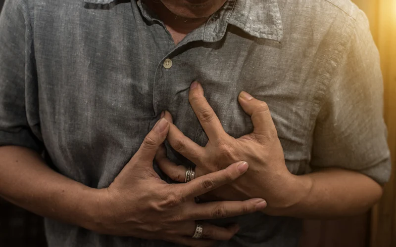 man holding heart pain
