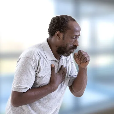 man wheezing with hand on chest and coughing into mouth