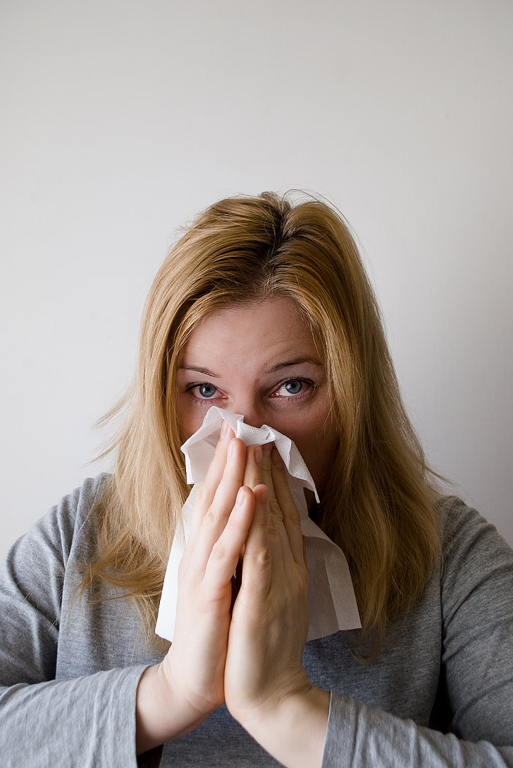 woman with tissue on the nose after sneezing