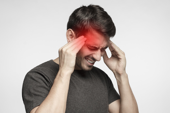 man with headache holding head