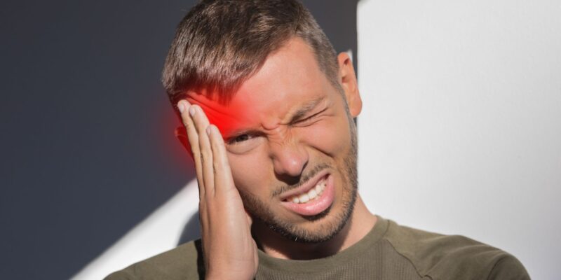 Manwith hand on head suffering headache